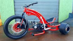 a red motorcycle parked in front of a garage door