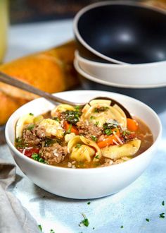 a white bowl filled with pasta and meat soup