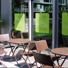 tables and chairs are lined up in front of the glass doors of a coffee shop