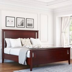 a bedroom with white walls and wood furniture