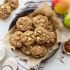 apples and oatmeal cookies in a bowl next to an apple on a table