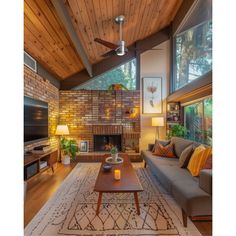 a living room filled with furniture and a flat screen tv on top of a wooden ceiling