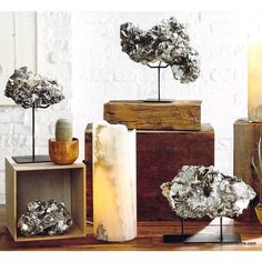 several different types of rocks on display in front of a white brick wall and wooden boxes