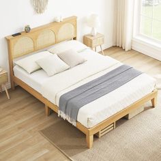 a bed sitting on top of a wooden floor next to a window