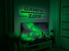 a man standing in front of a tv with the words gaming zone on it at night