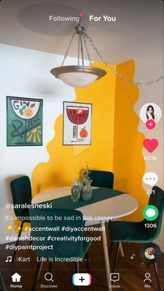 a room with yellow walls, green chairs and a white table in front of it