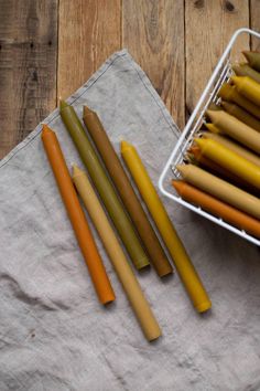 four different colored carrots are on a napkin next to a basket of carrot sticks