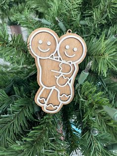 a wooden ornament hanging from a christmas tree with two people holding each other