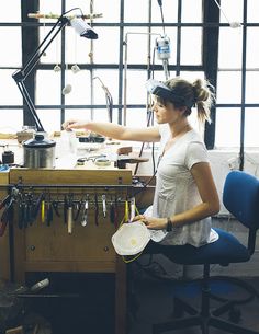 a woman working in an art studio with lots of tools