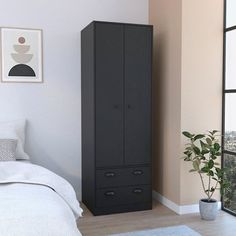 a black cabinet next to a white bed in a room with a plant on the floor