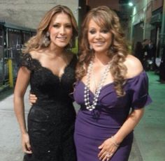 two women standing next to each other in formal wear and pearls on their necklaces