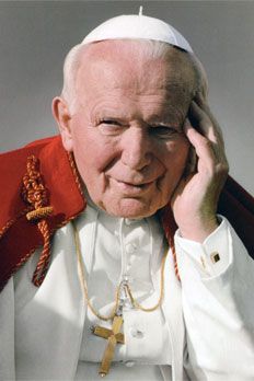 an older man wearing a red and white outfit holding his hand to his head while looking at the camera