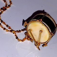 a small black and white object with gold chains on it's sides, sitting on a table