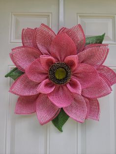 a pink flower is hanging on the front door