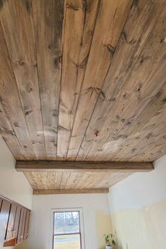 the ceiling is made from wood planks and has been painted white with brown trim