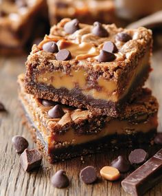 three pieces of chocolate peanut butter bars stacked on top of each other with chocolate chips