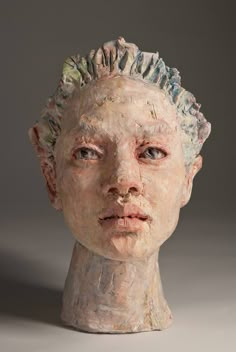 a clay head with hair on top of it