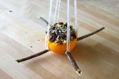 an orange is hanging upside down on the table with some food in it's middle