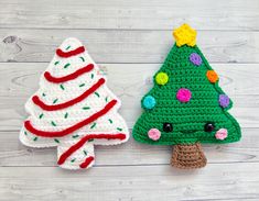 two crocheted christmas trees on a white wooden background, one is green and the other is red