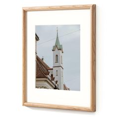 a framed photograph of a church steeple against a cloudy sky