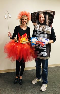 two people dressed in costumes standing next to each other with candy and marshmallows on their heads