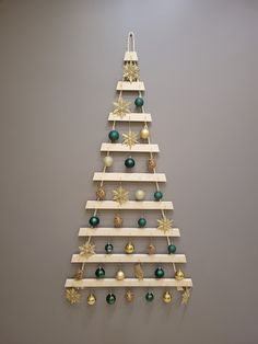 a christmas tree made out of wooden planks with ornaments hanging from the top and bottom