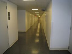 an empty hallway with white walls and doors