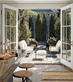 an open patio with white furniture and large windows