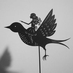 a black and white photo of a bird with a woman on it's back