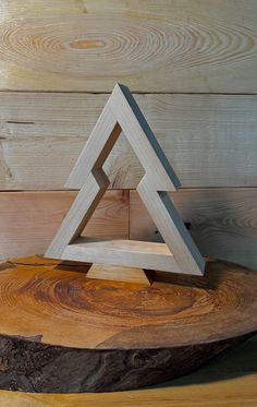 a wooden object sitting on top of a tree stump in front of a wood wall