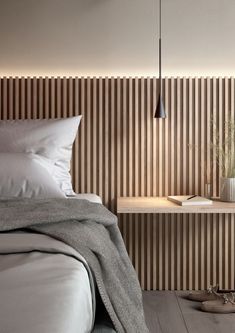 a bed with white sheets and pillows in front of a wooden headboard that has vertical slats on it