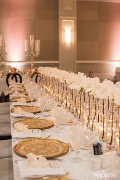 a long table with white flowers and place settings