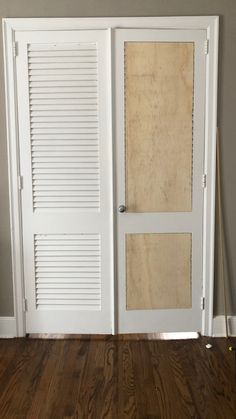 an empty room with two white doors and wood flooring in front of the door