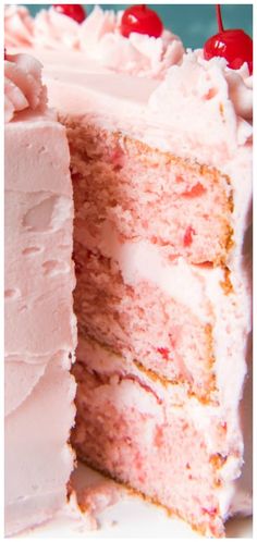 a close up of a cake with white frosting and cherries