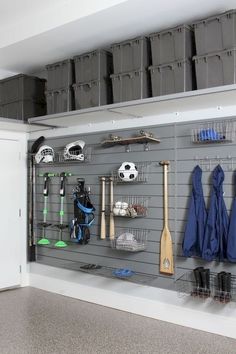 an organized garage with several storage bins and sports equipment