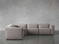 a beige couch sitting on top of a gray floor