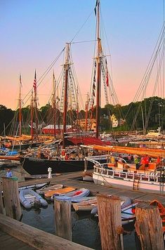 several boats are docked in the harbor at sunset