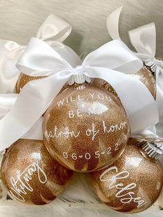 three christmas ornaments with writing on them sitting in a pile next to ribbons and bows