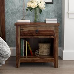 a wooden table with flowers and books on it