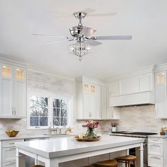 a white kitchen with an island and two stools in front of the counter top