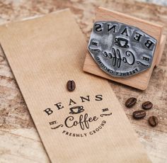 a rubber stamp that says beans coffee on it next to some coffee beans and a piece of paper