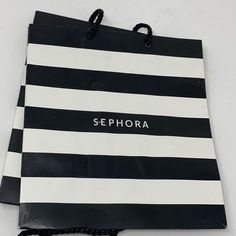 a black and white striped shopping bag with the word sephora on it's side