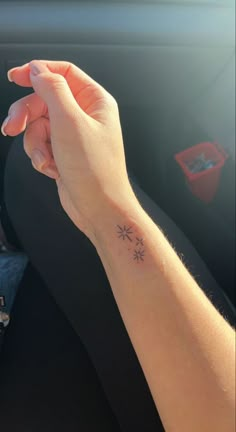 a woman's hand holding the wrist of another person with an arrow tattoo on it