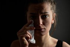 a woman holding a napkin to her nose