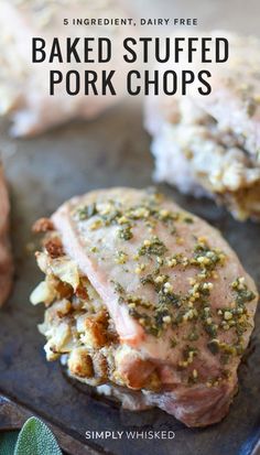 baked stuffed pork chops on a baking sheet with herbs and seasoning sprinkles