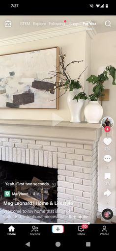 the fireplace is decorated with white vases and greenery