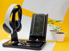 a cell phone and headphones sitting on a table next to a potted plant