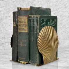 a bookend made out of two books and a seashell on top of them