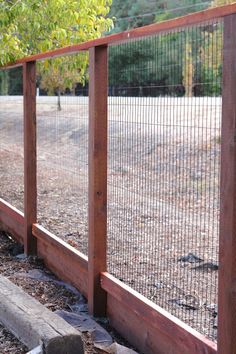 the fence is made of wood and wire, along with some rocks on the ground