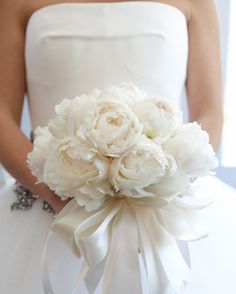 a bridal holding a bouquet of white flowers